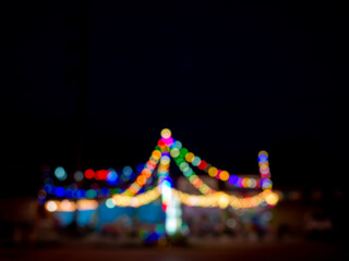 Abstract blur image of colorful light of night festival party bokeh on dark background. Blurred festive and celebration bokeh background. Blurry hanging light.