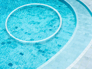 A round shape of a white line makes a decorated circle frame on the swimming pool background. Empty blank space border frame for summer, vacation time, holiday concept.