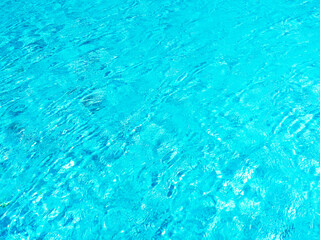 Clean and clear blue water surface movement on the swimming pool background. Empty blank space for summer background, vacation time, holiday concept.