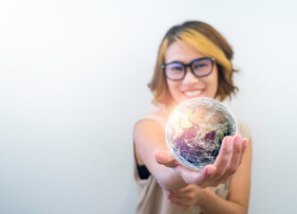 Earth in hand. World, small globe hold and showing by happy Asian woman's hand on white background with copy space. Earth day. Global connection, communication, and future network technology concept.