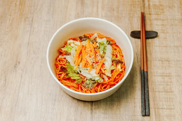 Jjolmyeon refers to thick flour noodles characterized by their chewiness. It is usually topped with cucumber, cabbage, and bean sprout and mixed with a gochujang (red chili paste) sauce at the table.