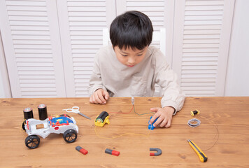 小学3年生の理科の勉強で豆電球の実験をするアジア人の男の子