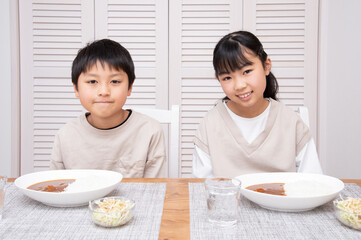 夕食にカレーライスを食べるアジア人の子供