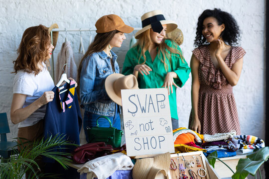 Young women at swap home party - clothes, shoes, bags, jewellery exchange between friends. Zero waste shopping, eco friendly concept, sustainable lifestyle. College life