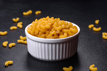 Detail of macaroni pasta useful as a background, texture. Dry pasta. Top view on black background