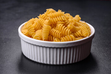 Detail of macaroni pasta useful as a background, texture. Dry pasta. Top view on black background