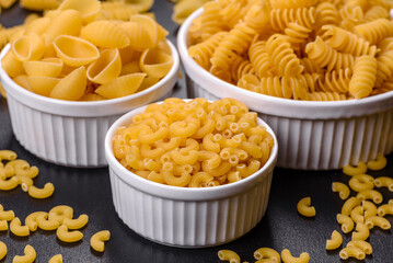 Detail of macaroni pasta useful as a background, texture. Dry pasta. Top view on black background