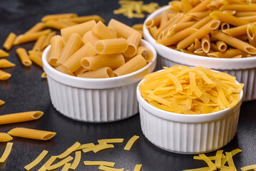 Detail of macaroni pasta useful as a background, texture. Dry pasta. Top view on black background