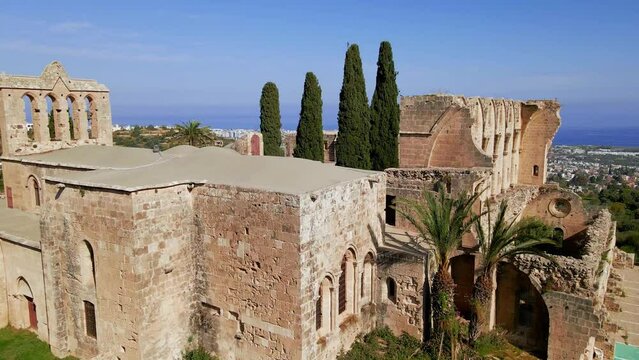 Aerial 4K view of beautiful Bellapais Village with Bellapais Monastery in Kyrenia, North Cyprus surrounded with an amazing green Mediterranean nature and picturesque landscapes in Cyprus.