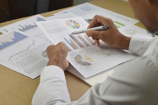 business man working with graphs and charts report on desk in office.