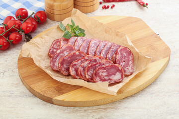 Sliced salami sausages over board