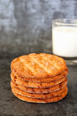 Stack of cinnamon crispbreads and glass of milk in the background