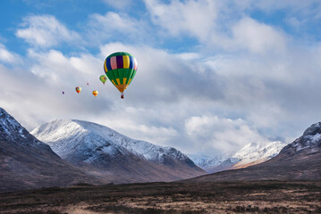 Digital composite image of hot air balloons flying over Majestic beautiful Winter landscape image of Lost Valley in Scotland