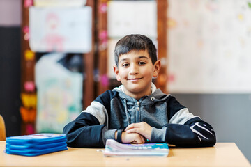 Portrait of a smart Roma boy following lecture and smiling at the camera. - obrazy, fototapety, plakaty