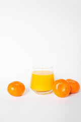 Glass of fresh orange juice with three citrus mandarin fruits near. Isolated on the white background.