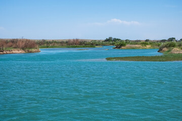 Ili river in spring time. Beautiful river with blue water and sky. Wild nature landscape background.