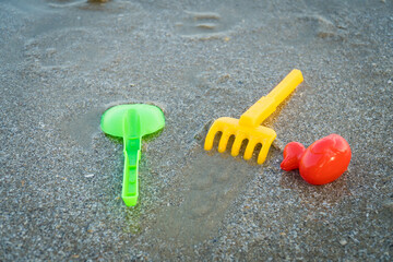 Fototapeta na wymiar Children's beach toys. plastic children toys on the sand beach. copy space for text.