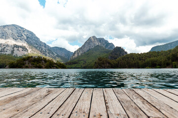 Boards background with landscape of mountains and lake for your decoration. Beautiful nature, white clouds, template table.