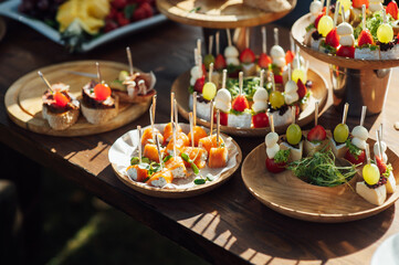 A table of various snacks, sandwiches, strawberries and other types of snacks.