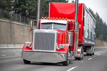 Beautiful bright red classic big rig semi truck tractor with chrome and lights accessories...