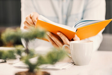 Close up of entrepreneur's hands holding agenda with scheduled meetings at home office.