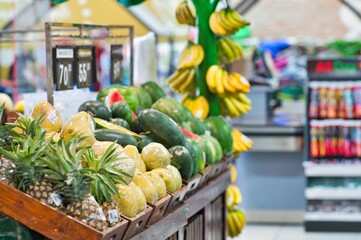 Yellow pineapples and fruits displayed on the shelf in the grocery super market of Philippines