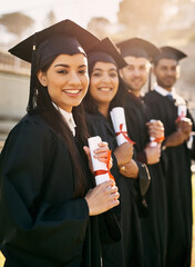 Its such a life-changing moment. Portrait of a group of students standing in a line on graduation...