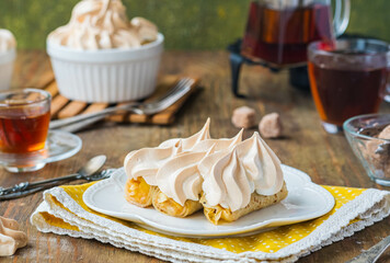 Dessert, thin pancakes with apple filling baked under meringue on a white plate on a green concrete background. Pancake recipes, international pancake day.