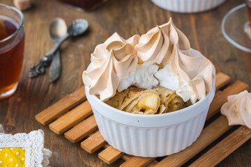Dessert, thin pancakes with apple filling baked under meringue in portion form on a green concrete background. Pancake recipes, international pancake day. Ukrainian food