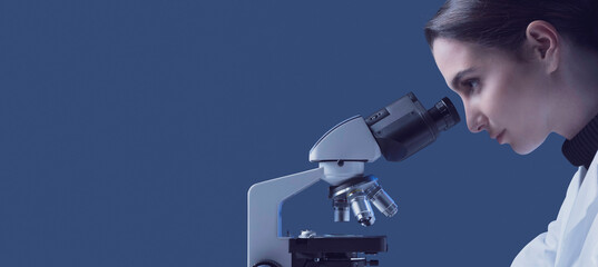 Young researcher using a microscope