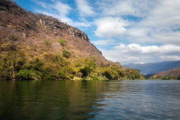 Obraz premium Sumidero Canyon is a deep natural canyon located on the Grijalva River in Chiapas in Southern Mexico. The Canyon's vertical walls can reach up to 1,000 meters high and it is covered with rainforest.