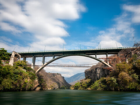 A high Bridge over Grijalva river at the Sumidero Canyon, a natural deep canyon in Chiapas, Yucatan, Mexico. View from the water on a boat tour of the Canyon, a popular attraction in Southern Mexico.