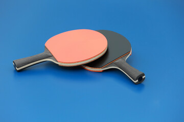 Raquettes de tennis de table posées sur une table bleue en extérieur