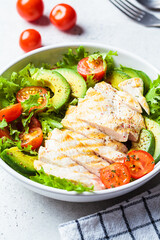 Grilled chicken breast salad with avocado and cherry tomatoes. Healthy diet food concept.