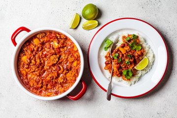 Chili con carne - minced meat with vegetables and beans in tomato sauce with rice in bowl. Mexican...