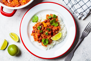 Vegan chili con carne with vegetables and beans in tomato sauce with rice in plate. Mexican food concept.