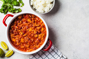 Chili con carne - minced meat with vegetables and beans in tomato sauce in a red saucepan. Mexican...