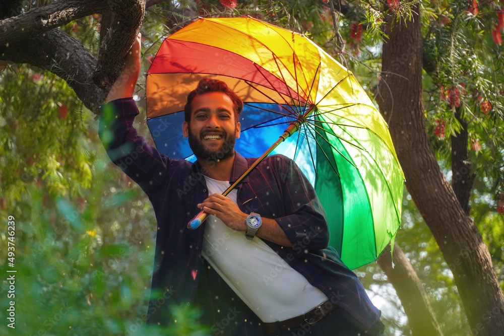 Wall mural man with umbrella in spring season with flowers in background