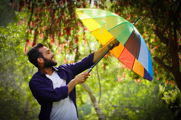man with umbrella in spring season with flowers in background