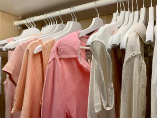 female pastel clothes hanging on hangers