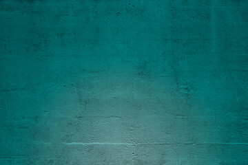 Close-up of plastered and painted blue green concrete wall with light effect. Abstract high resolution full frame textured background. Copy space.