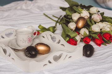 Sill life spring white and red tulips with golden and white easter eggs