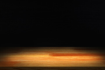 light brown wood table on dark background.