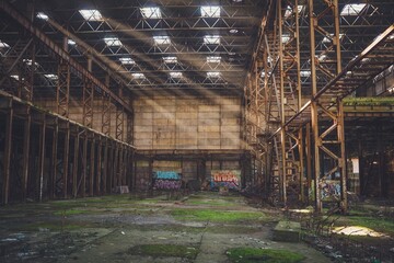 The sun's rays break through the roof of an abandoned warehouse 