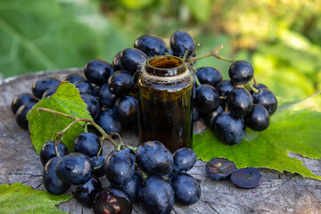 Grape seed oil in a glass jar and fresh grapes for spa and body care. The concept of spa, bio, eco products