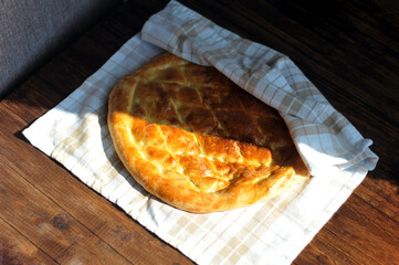 Freshly baked fragrant homemade bread flatbread on the table under the morning sun