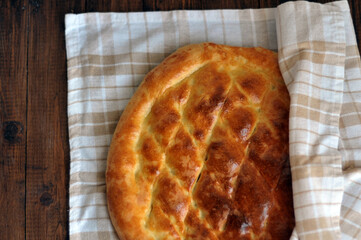 Freshly baked fragrant homemade bread flatbread on the table under the morning sun