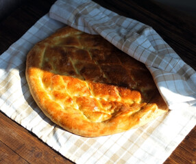 Freshly baked fragrant homemade bread flatbread on the table under the morning sun