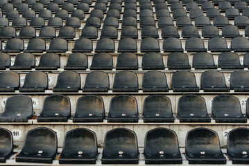 Fototapeta premium Empty stands and seats for fans and fans in the open-air stadium. Lack of fans during the pandemic.