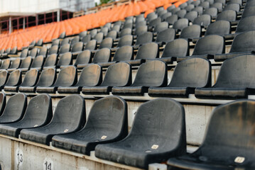 Fototapeta premium Empty stands and seats for fans and fans in the open-air stadium. Lack of fans during the pandemic.